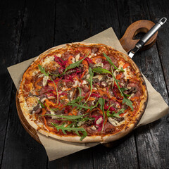 delicious pizza with cheese, greens, sauce in a restaurant
