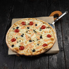 delicious pizza with cheese, greens, sauce in a restaurant
