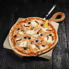 delicious pizza with cheese, greens, sauce in a restaurant
