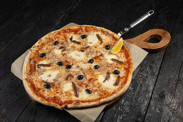 delicious pizza with cheese, greens, sauce in a restaurant
