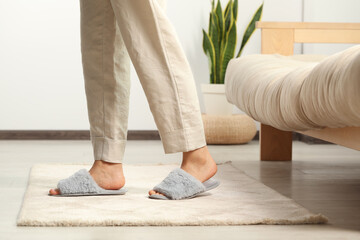 Woman wearing soft slippers at home, closeup