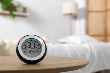 Digital hygrometer with thermometer on wooden table indoors. Space for text - obrazy, fototapety, plakaty