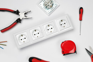 Set of sockets and electrician's tools on white background, top view