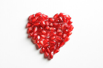 Fototapeta na wymiar heart of pomegranate seeds on white background