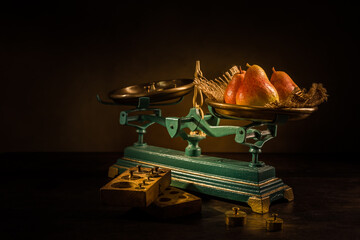 Organic pears on old vintage scales with brass weights on wooden background