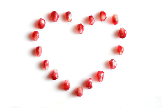 silhouette of red heart with pomegranate seeds on the white background