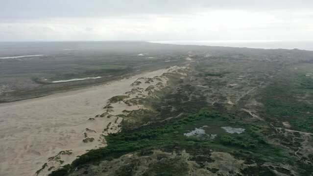 High-angle scenic view of a beautiful landscape of sand dunes covered in greenery in Denmark