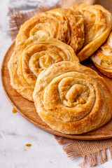 Close up of a traditional vegetarian rolled pies on a wooden round board 