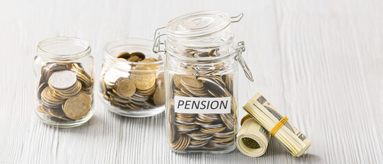 Jars with coins on wooden table. Concept of pension