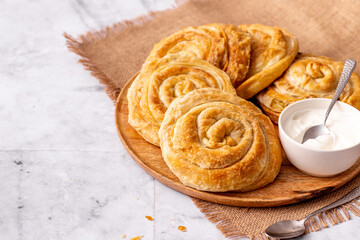 Close up of the traditional Serbian rolled vegetarian cabbage pie for breakfast on a marble table in rustic style