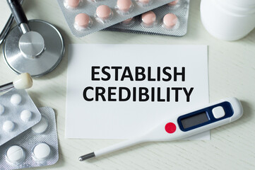 ESTABLISH CREDIBILITY on a card on a doctor's desk among medical devices