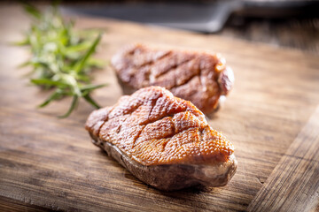 Roasted duck breast on a cutting board ready for slicing and serving
