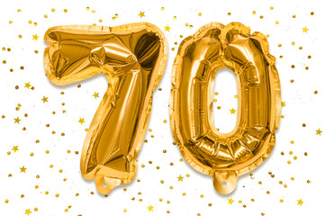 The number of the balloon made of golden foil, the number seventy on a white background with...