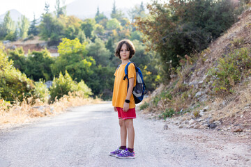 boy with a backpack dancer. smiling boy on a hike.