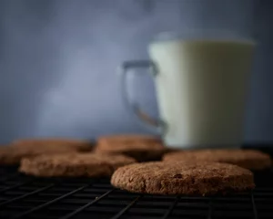 Fotobehang Chocolate cookies and cup of milk © Milos Maric/Wirestock Creators