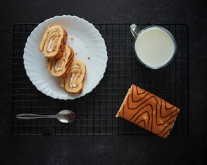 Keuken foto achterwand Top view of biscuit roll and cup of milk © Milos Maric/Wirestock Creators