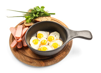 Frying pan with fried quail eggs, sausages, bread and greens on white background