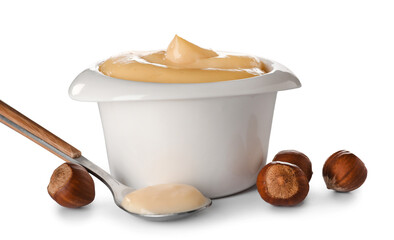 Ramekin of tasty vanilla pudding and hazelnuts on white background