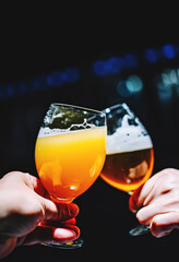 Two friends hands toasting with glasses of light beer at the pub or bar