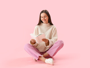 Beautiful woman reading book on pink background