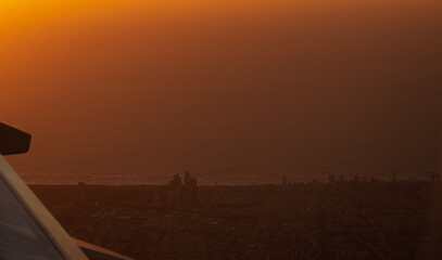Sunset over Tel Aviv. Aerial view from a commercial airplane with the coast and beach of Tel Aviv city at Mediterranean sea from Israel.