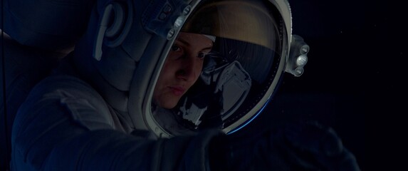 Portrait of female astronaut performing spacewalk, working on a outer part of a space craft. Space exploration, Mars mission