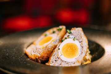 Traditional Scotch egg . Skirly is fried oatmeal with onions and spices, a classic garnish of Scotland. Honey mustard sauce. Traditional cuisine of Scotland.