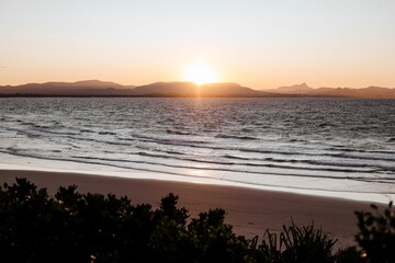 Bright orange sunset sky over Little Wategos Beach in Byron Bay, Australia