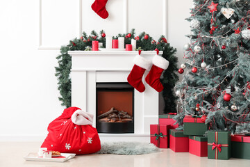 Obraz premium Interior of light living room with Santa bag, fireplace and Christmas tree