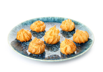 Plate with delicious eclairs on white background