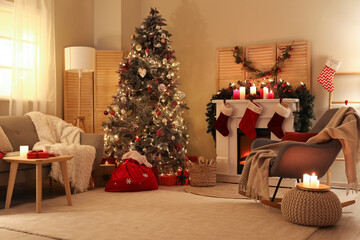 Interior of living room with Christmas tree, sofa and armchair