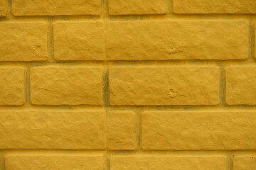 Closeup of bright yellow painted brick veneer wall