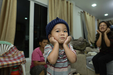 A boy in a blue knitted hat is doing a cute pose.