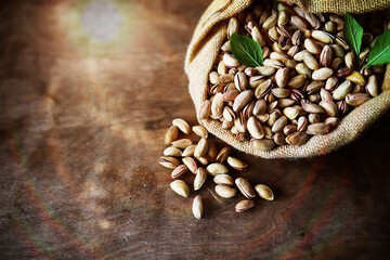 Roasted salted pistachios. Dried pistachios in small sack on  table.