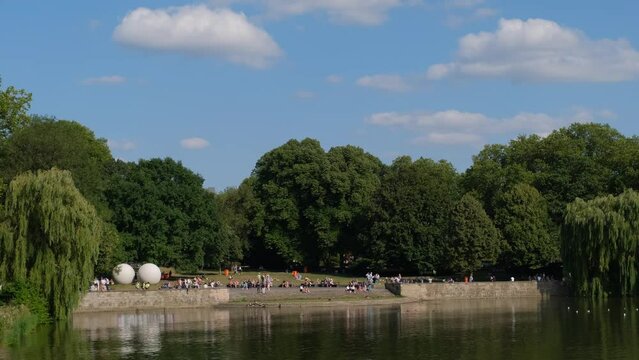 Many people relax on the promenade of Lake Aasee in the center of Munster on their day off.