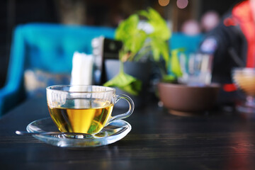 Hot steaming green tea in a cup on a rustic background