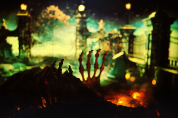 Zombie skeleton hand rising in dark Halloween night.