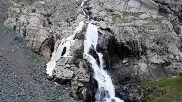 The camera drone goes up the waterfall and takes pictures of the river and waterfall and carries a supply of fresh water among the mountains