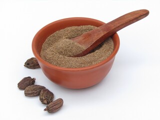 Black cardamom powder in a bowl on white background 