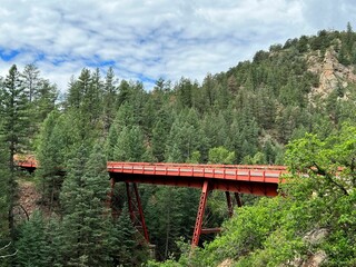 Beautiful view of Gold Belt Byway bridge over Phantom Canyon Road under green forest mountains