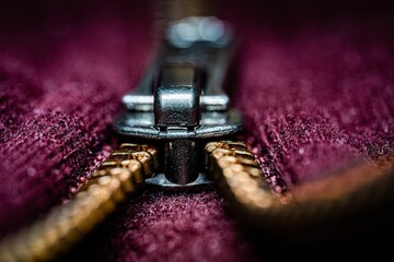 Close-up view of a Bordeaux-colored cloth zip pulling © Znmiliuphoto/Wirestock Creators