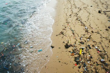 Naklejka premium High-angle shot of a beach full of trash