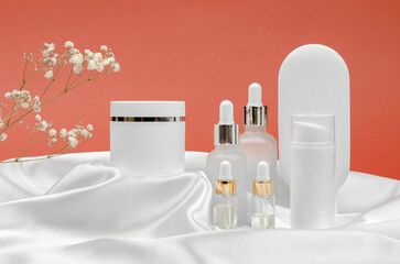 Cosmetic products on a podium made of silk fabric. Cream, mask, lotion and serum for face and body...