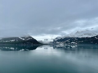 Landscape with frozen lake and snowy mountains on a cloudy day in Alaska