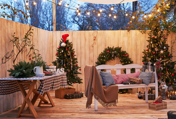 New Year and Christmas backyard decorations. Christmas tree, wreath and gifts. Winter holidays and celebrations