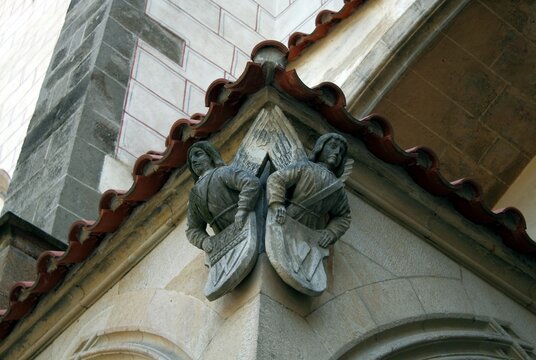 Close-up Shot Of Angel Sculptures Hanging From The Building's Corner