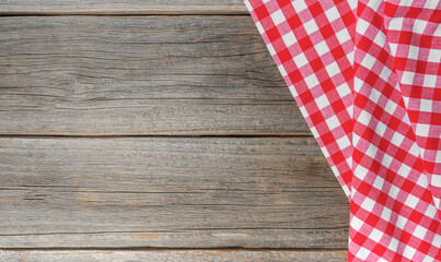 Checkered tablecloth on a wooden background. There is a place for your text.