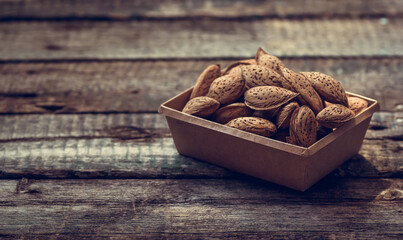 Almonds in shell on wooden background