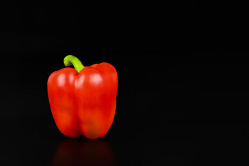 Red pepper over black background