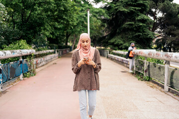 Fototapeta na wymiar Happy Muslim Woman Using Cellphone
